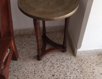 Mesa de latón con caligrafía árabe y diseños geométricos sirios. Sobre pie de madera. 